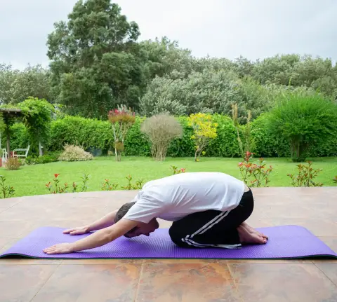 homme qui fait du yoga dans jardin