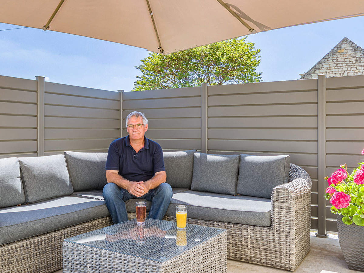 photo d'un homme sur sa terasse avec sa clôture Litenn